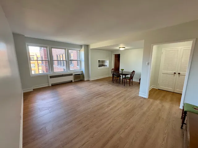 an empty room with wooden floor and a window