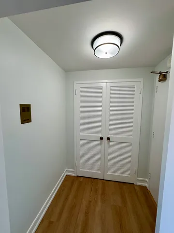 a view of a room with wooden floor and white walls