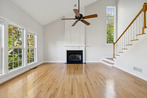 an empty room with windows and ceiling fan
