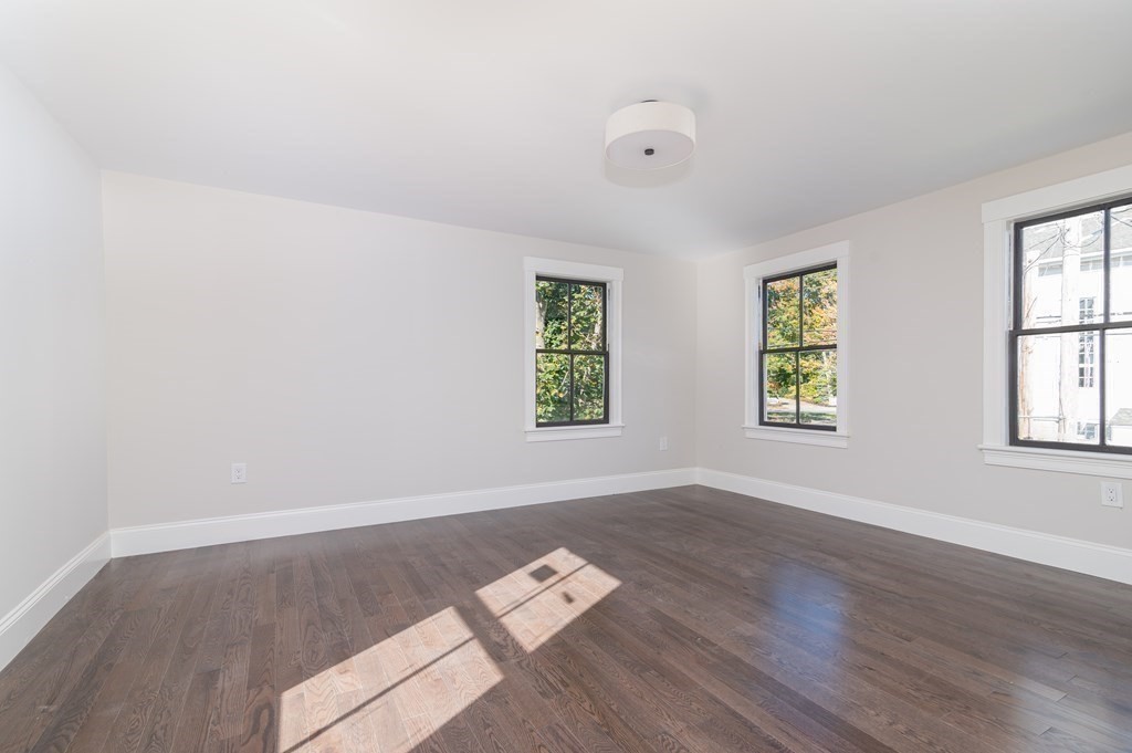 5 Pleasant Street, Unit 3 Hingham, MA 02043 - Photo 16 of 25 an empty room with wooden floor and windows