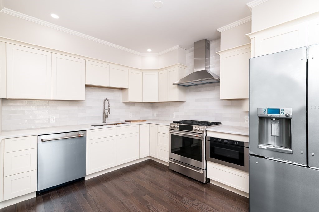 5 Pleasant Street, Unit 3 Hingham, MA 02043 - Photo 3 of 25 a kitchen with stainless steel appliances granite countertop a stove and white cabinets