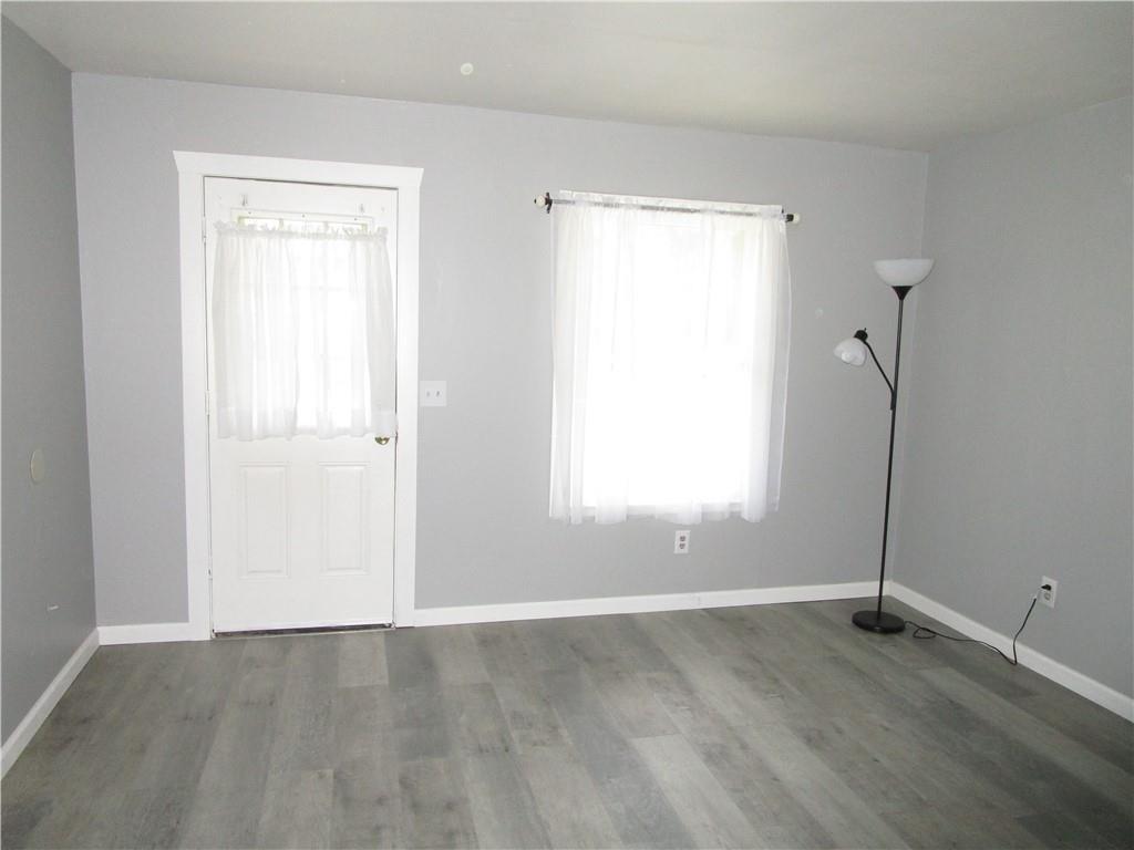 1124 Webster Street Farrell, PA 16121 - Photo 6 of 17 an empty room with wooden floor and windows