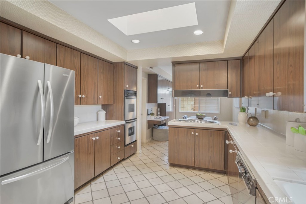 16355 Tudor Drive Encino, CA 91436 - Photo 15 of 51 a kitchen with stainless steel appliances a refrigerator sink and cabinets
