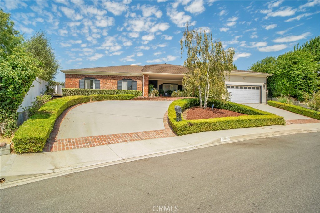 16355 Tudor Drive Encino, CA 91436 - Photo 2 of 51 a front view of a house with a garden and trees