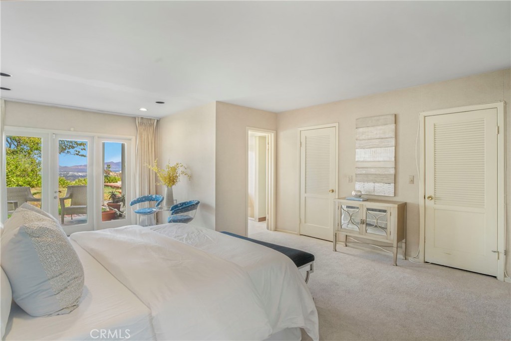 16355 Tudor Drive Encino, CA 91436 - Photo 22 of 51 a spacious bedroom with a bed a table and a large window