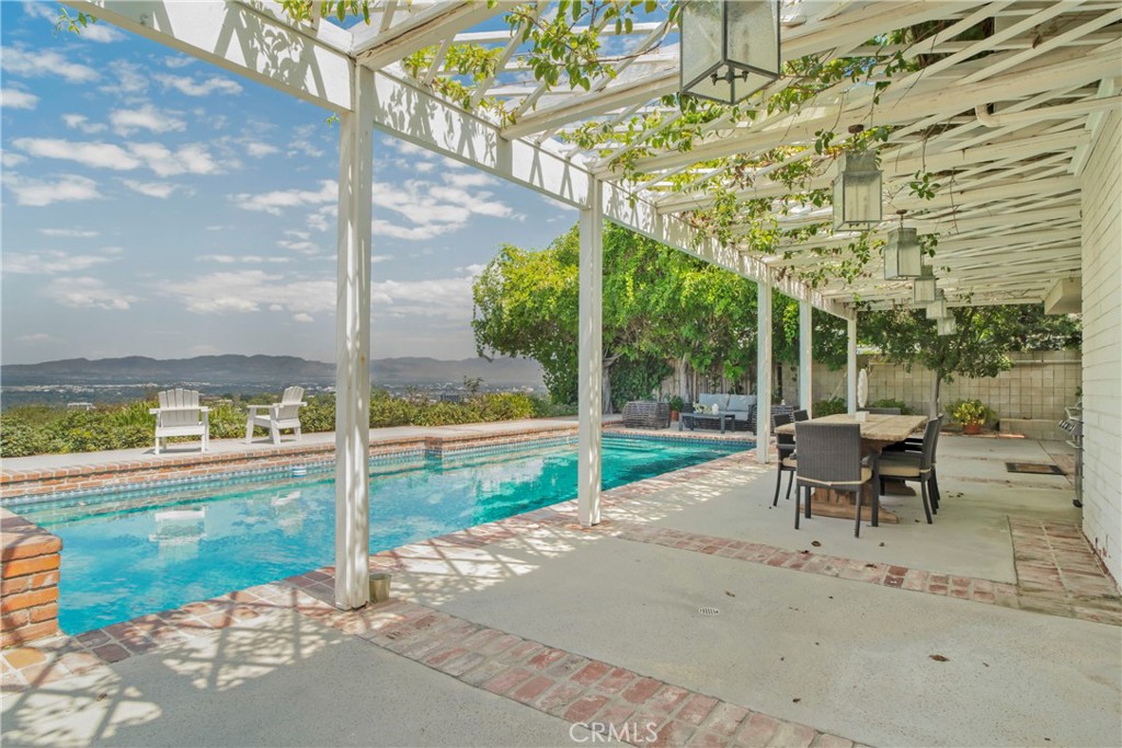 16355 Tudor Drive Encino, CA 91436 - Photo 40 of 51 a view of a porch with chairs and backyard of the house