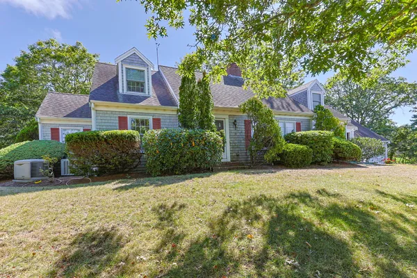 a front view of a house with a yard and trees
