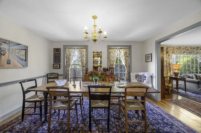 a view of a dining room with furniture a chandelier and wooden floor