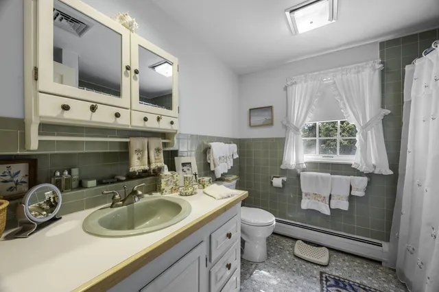 a bathroom with a sink a toilet and mirror