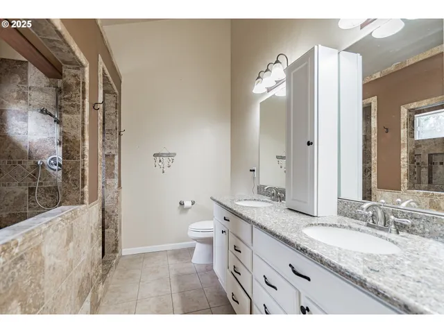 a bathroom with a granite countertop sink mirror and a toilet