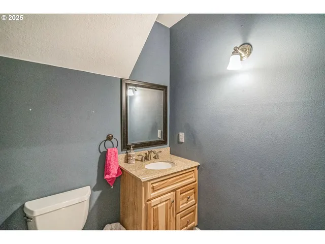 a bathroom with a sink vanity mirror and toilet