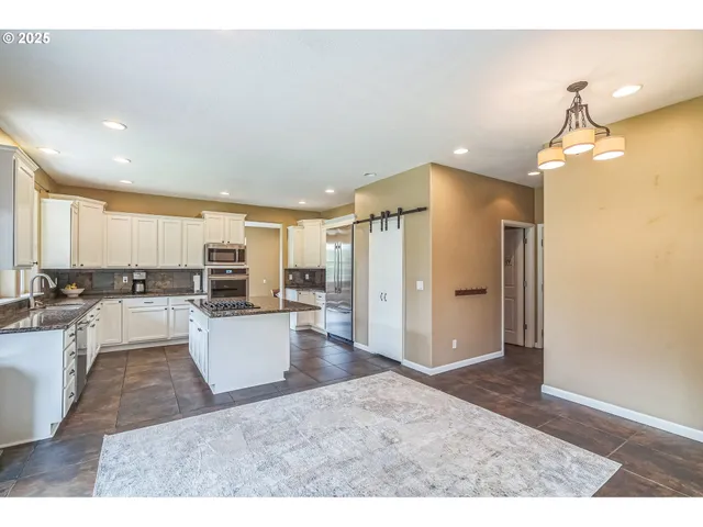 a open kitchen with white cabinets and stainless steel appliances