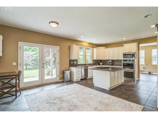 a open kitchen with a sink and white cabinets