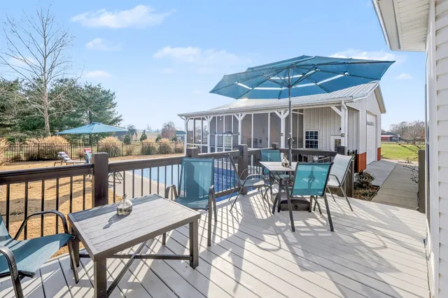 a view of a patio with table and chairs a barbeque with wooden floor and fence