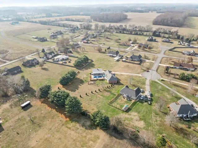 an aerial view of ocean and residential houses with outdoor space