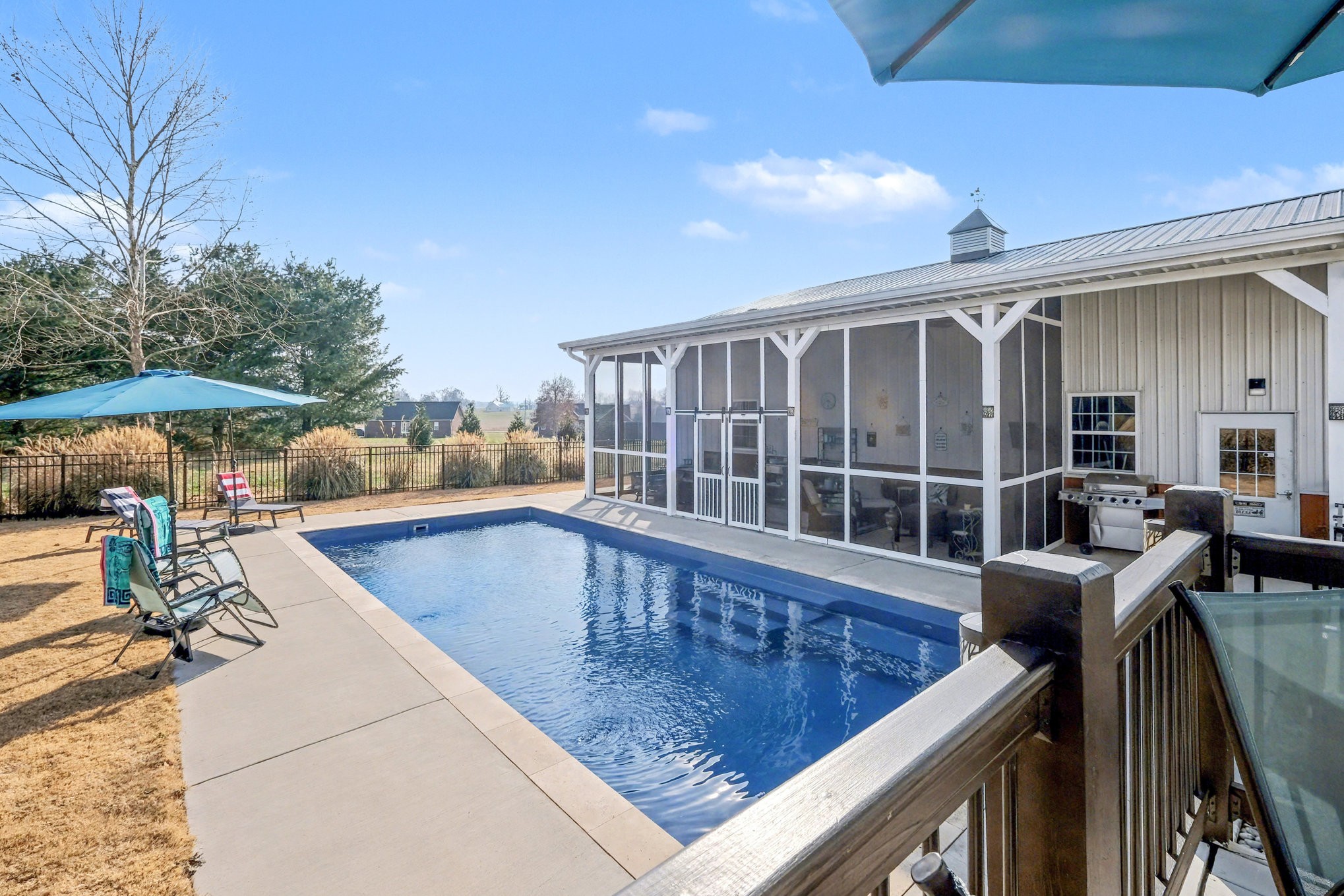 1002 Roland Court Cottontown, TN 37048 - Photo 4 of 41 a view of a patio with couches table and chairs under an umbrella with a barbeque