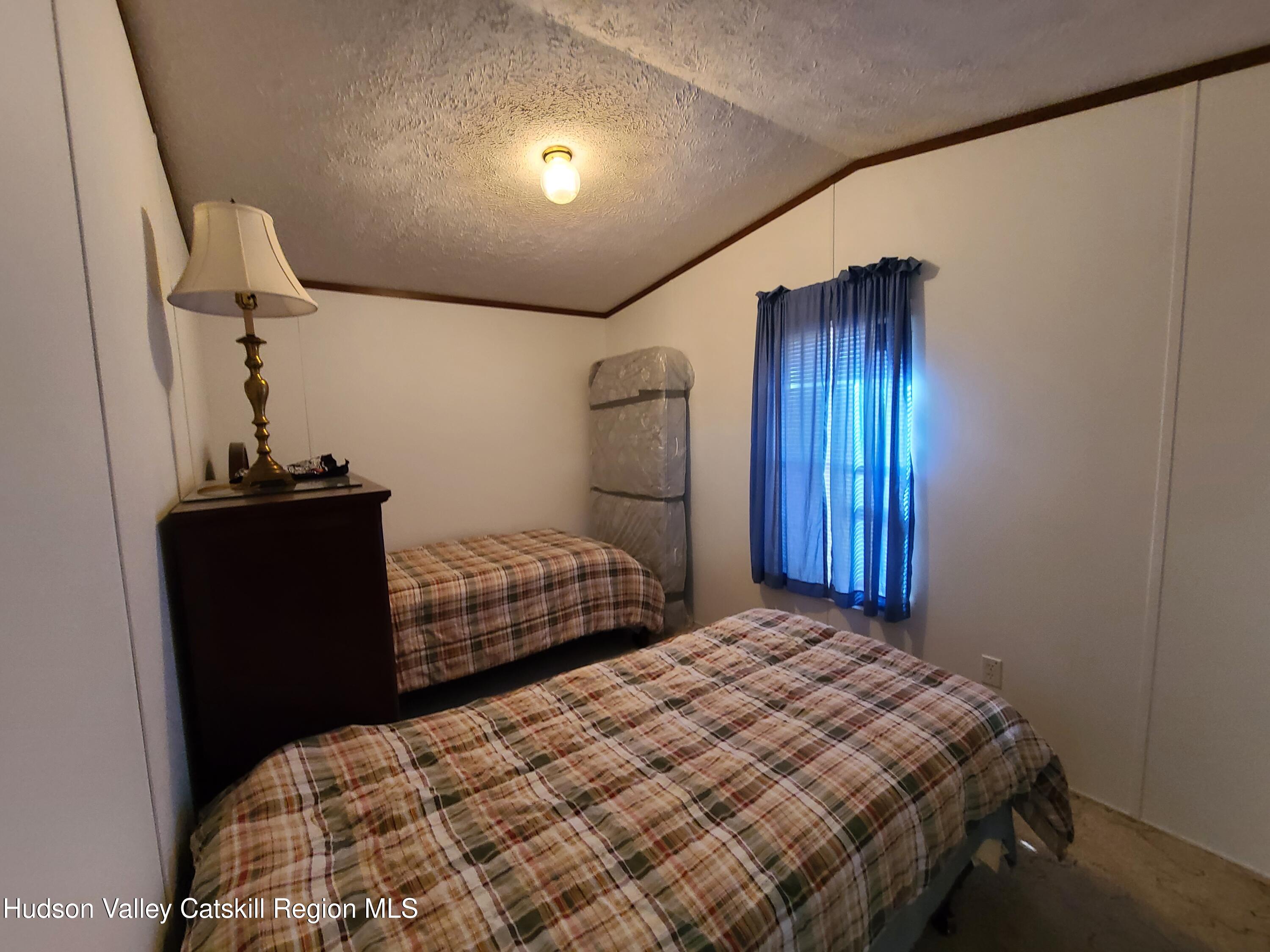 25 George Segar Road Bethel, NY 12783 - Photo 14 of 28 a bedroom with a bed and a chandelier