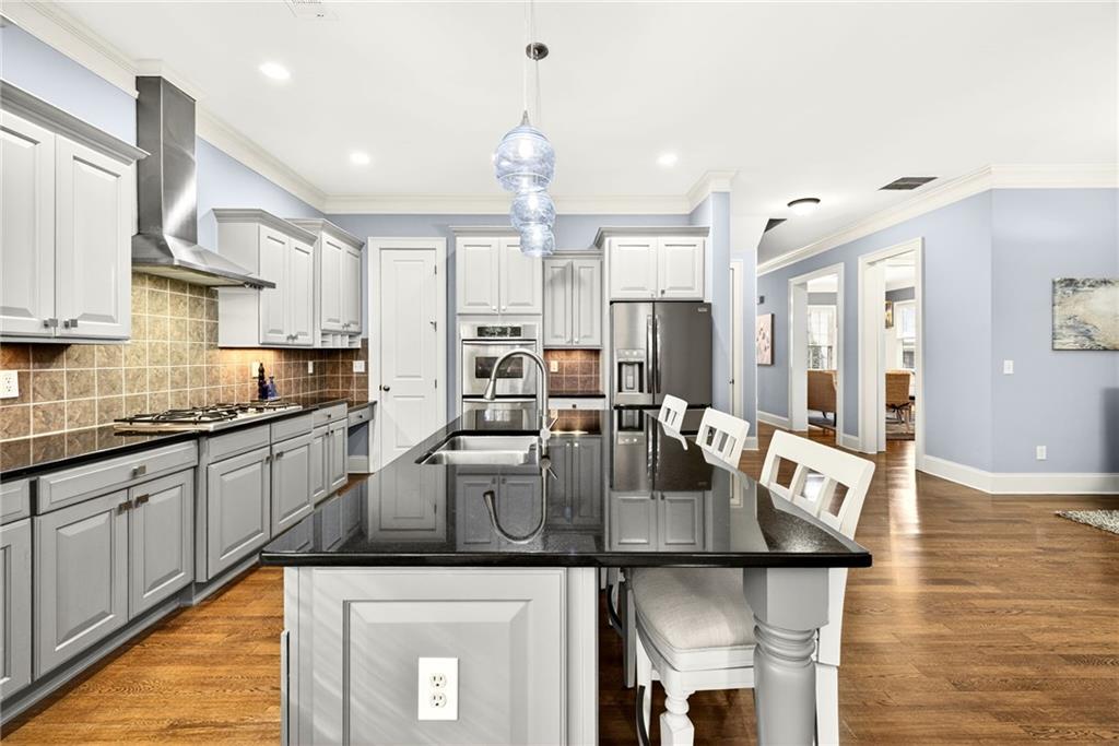 455 High Pointe Trail Roswell, GA 30076 - Photo 12 of 46 a kitchen with stainless steel appliances granite countertop a stove a sink dishwasher and cabinets with wooden floor