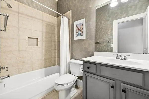 a kitchen with stainless steel appliances granite countertop a stove a sink dishwasher a refrigerator and white cabinets with wooden floor