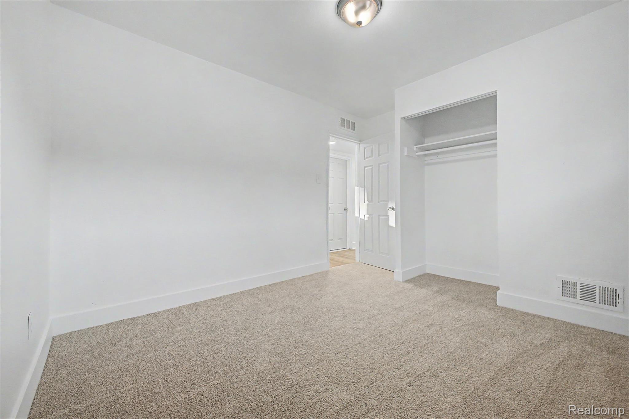 26718 Penn Street Inkster, MI 48141 - Photo 16 of 27 Room featuring neutral carpet, white walls, white trim, and an integrated closet with shelving and hanging rods