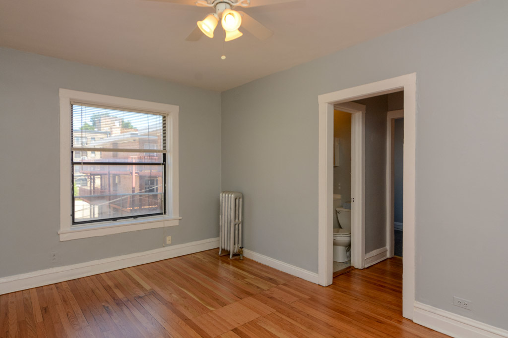 4606 North Beacon Street, Unit 2B Chicago, IL 60640 - Photo 16 of 20 an empty room with wooden floor and windows