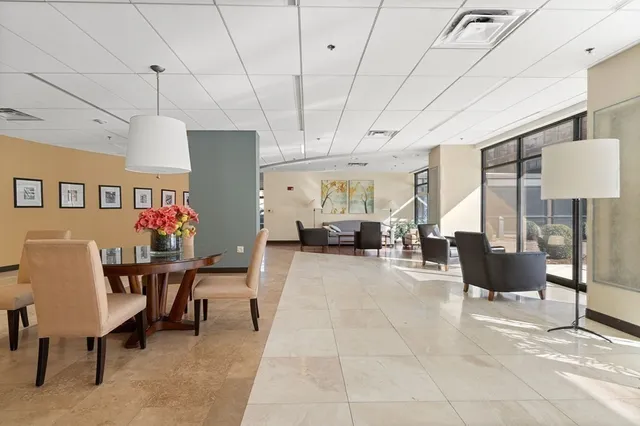 a living room with furniture a chandelier and a dining table