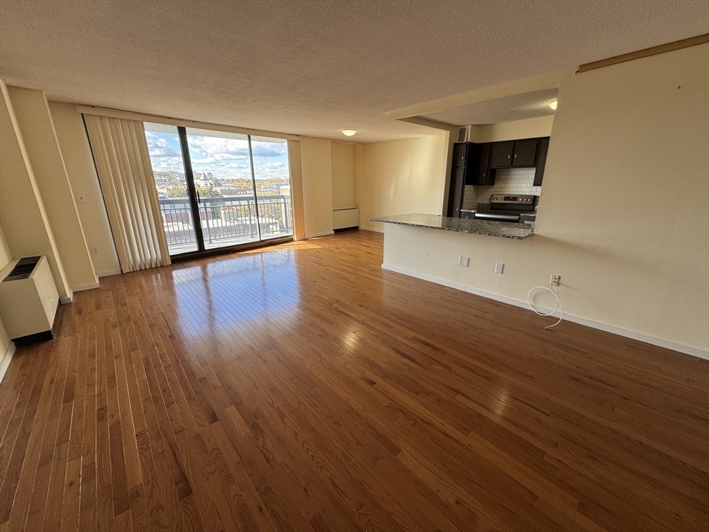 60 Longwood Avenue, Unit 802 Brookline, MA 02446 - Photo 6 of 16 a view of an empty room with wooden floor and a window