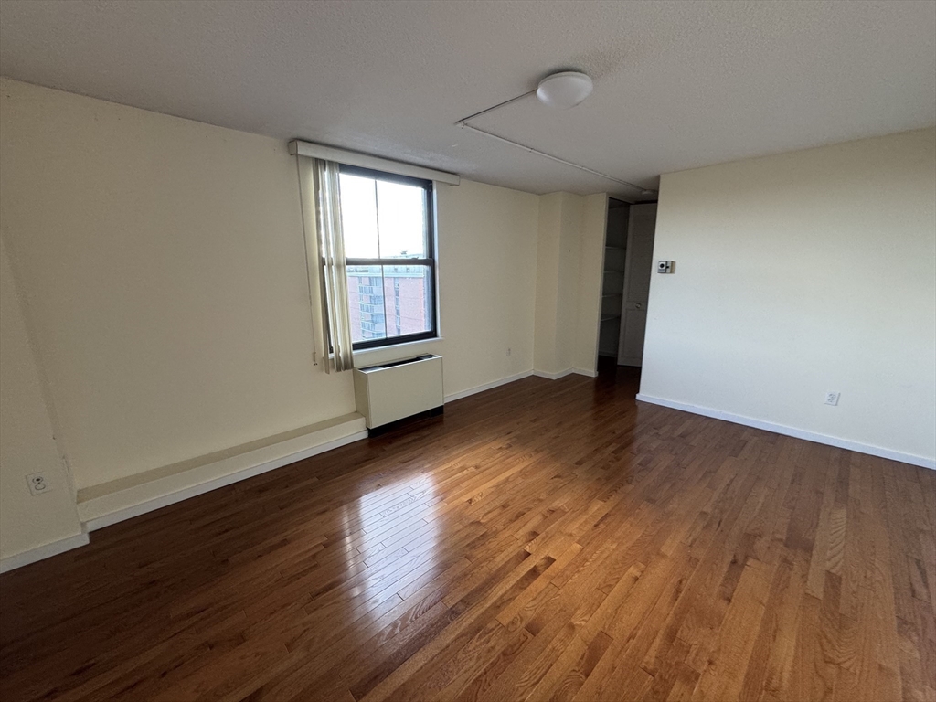 60 Longwood Avenue, Unit 802 Brookline, MA 02446 - Photo 8 of 16 an empty room with wooden floor and windows