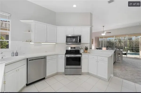 a kitchen with white cabinets and appliances