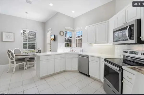 a kitchen with cabinets appliances and a dining table