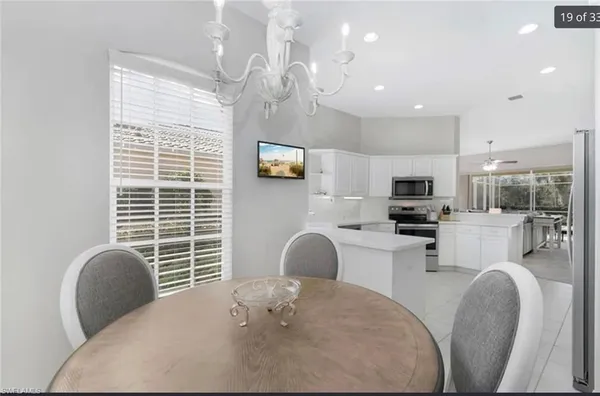 a kitchen with stainless steel appliances a stove a sink a dining table and chairs