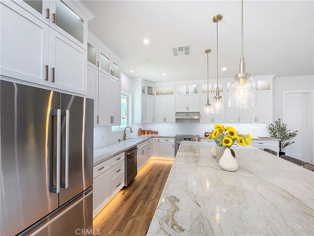 30233 Del Rey Road Temecula, CA 92591 - Photo 13 of 64 a kitchen with stainless steel appliances kitchen island granite countertop a refrigerator a stove and a sink