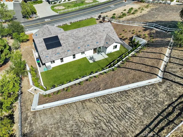 an aerial view of a house with a garden and trees