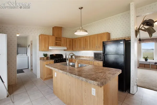 a kitchen with granite countertop a refrigerator a stove a sink and dishwasher