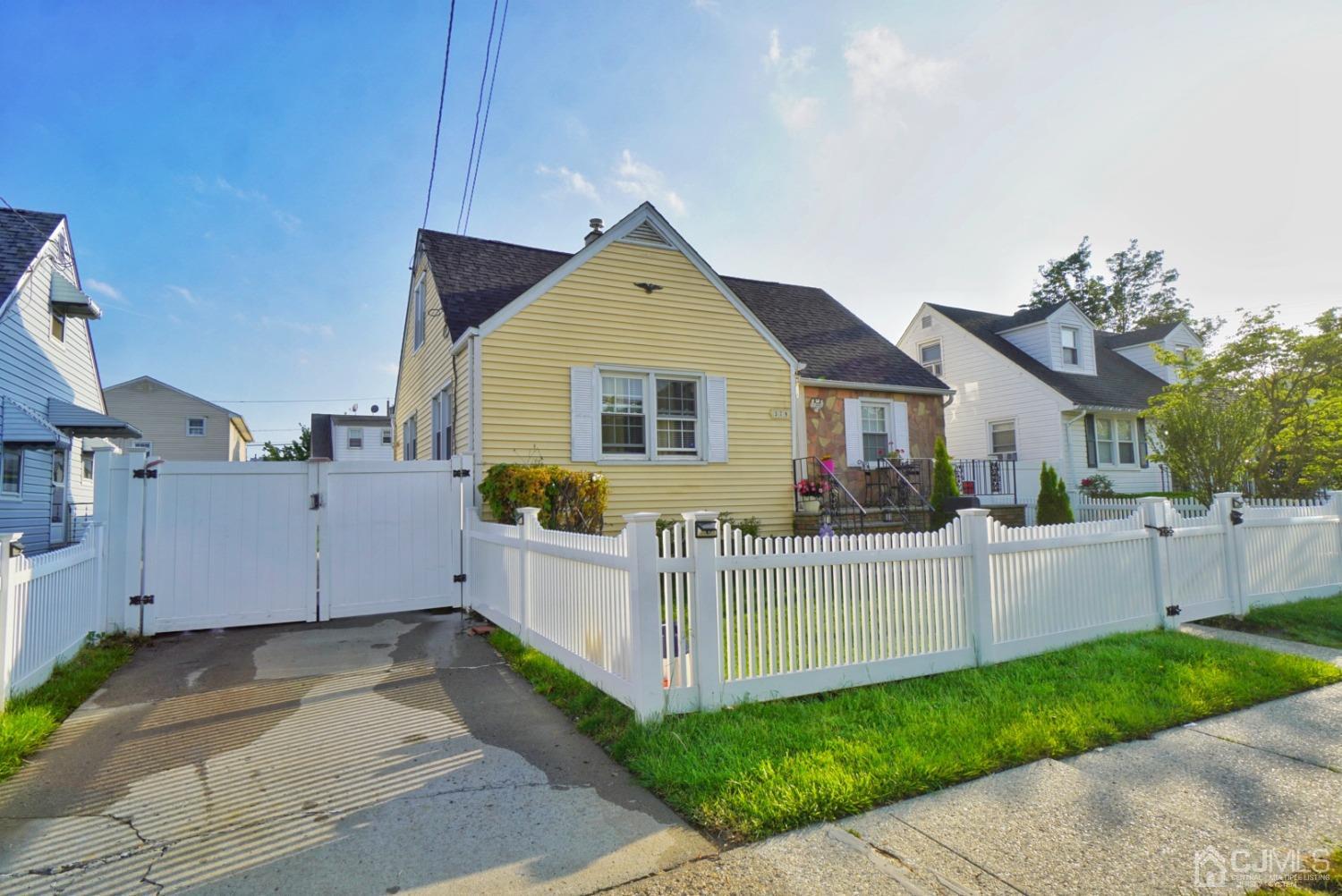 a view of a house with a small yard and wooden fence