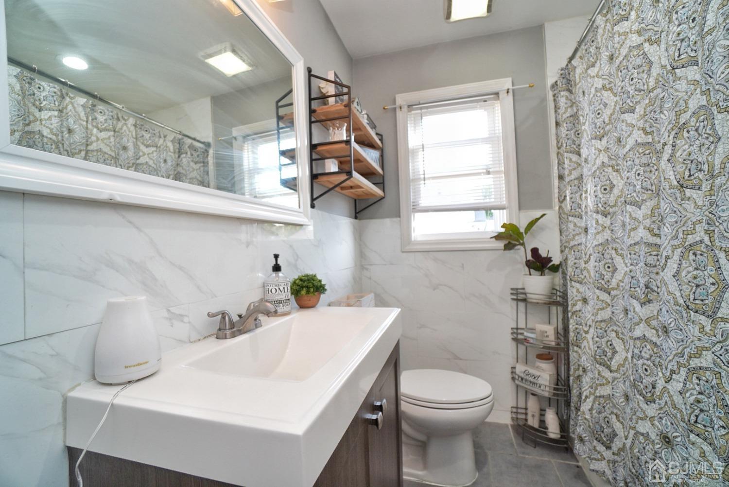 379 Summit Avenue Perth Amboy, NJ 08861 - Photo 13 of 22 a bathroom with a sink a toilet and a window