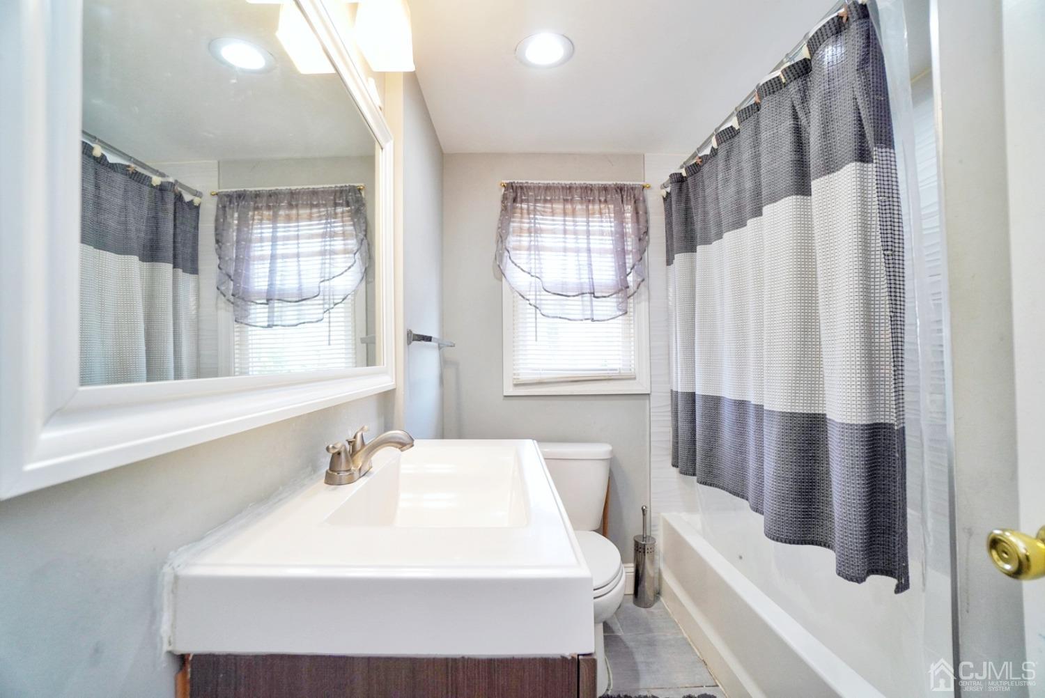 379 Summit Avenue Perth Amboy, NJ 08861 - Photo 17 of 22 a bathroom with a sink a toilet and a window