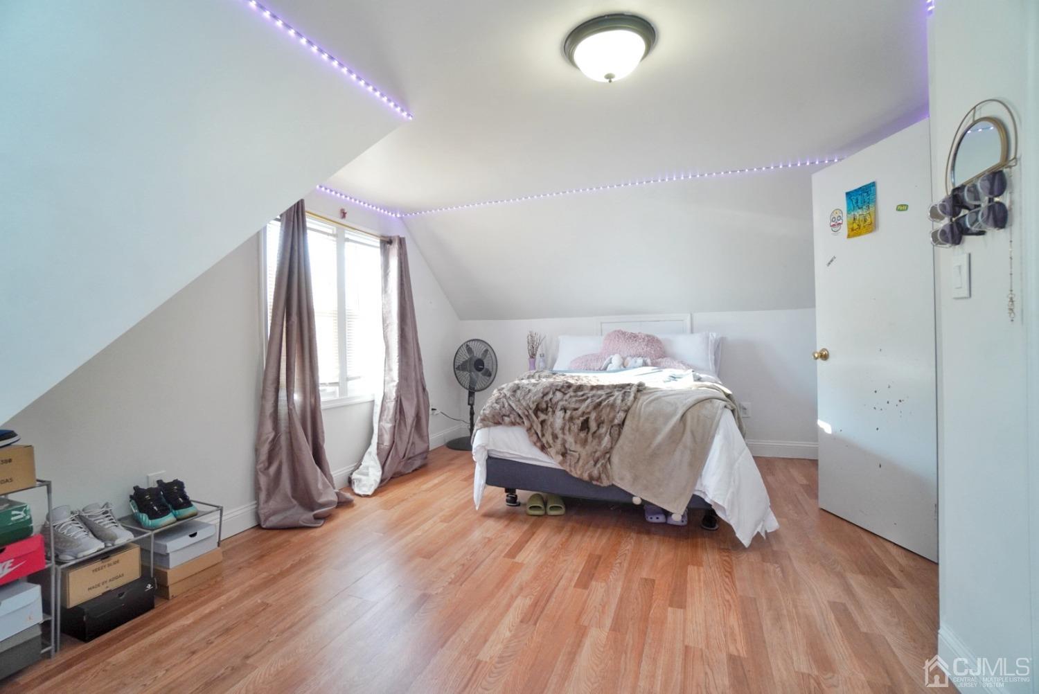 379 Summit Avenue Perth Amboy, NJ 08861 - Photo 18 of 22 a bedroom with a bed and a wooden floor