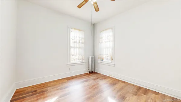 an empty room with a window and wooden floor