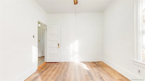 a view of a room with wooden floor and a window