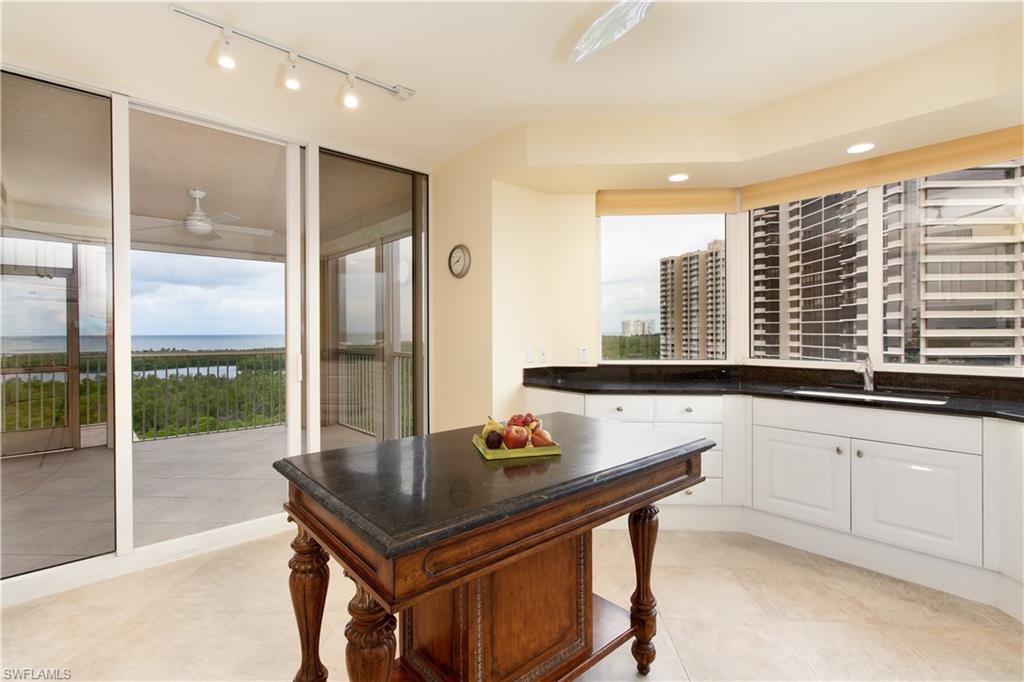 6597 Nicholas Boulevard, Unit 1006 Naples, FL 34108 - Photo 3 of 6 a kitchen with a sink a counter top space and living room view
