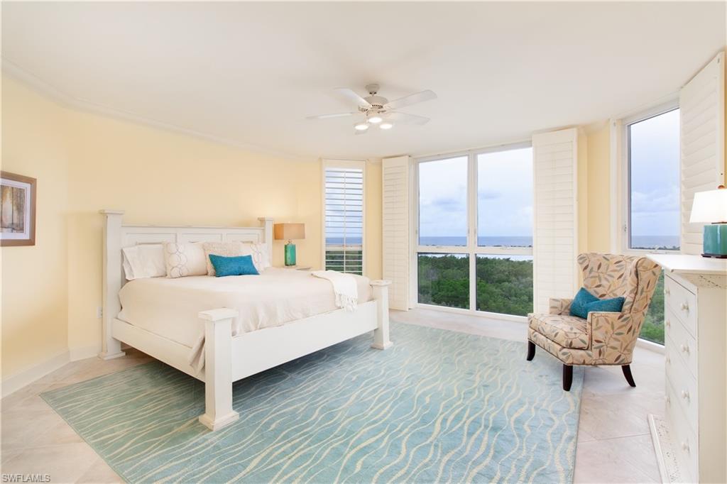 6597 Nicholas Boulevard, Unit 1006 Naples, FL 34108 - Photo 5 of 6 a bedroom with a bed and large windows