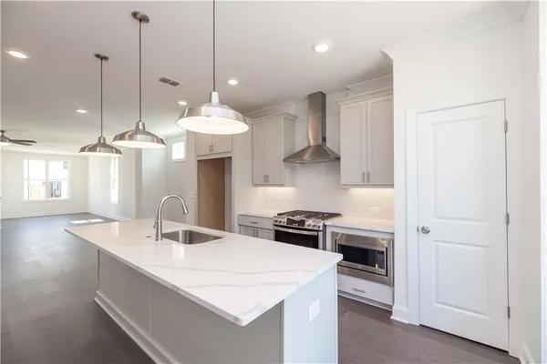 a kitchen with stainless steel appliances kitchen island a sink a stove and cabinets