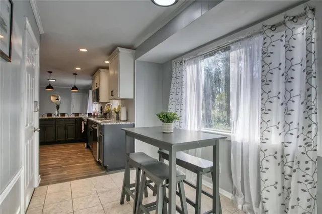 a kitchen with a table chairs refrigerator and cabinets