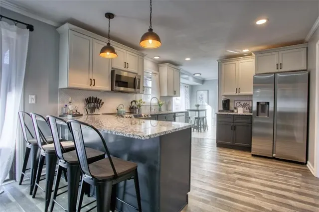 a kitchen with kitchen island a counter space a sink appliances and cabinets