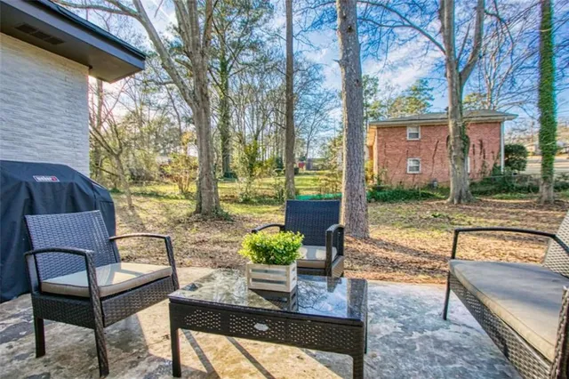 a view of a patio with couches table and chairs and potted plants