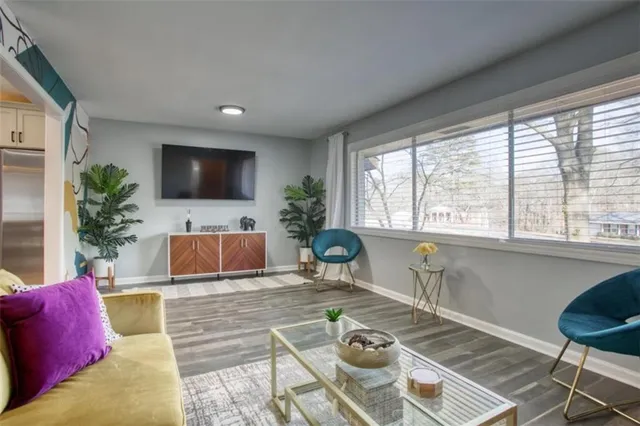a living room with furniture a flat screen tv and a large window