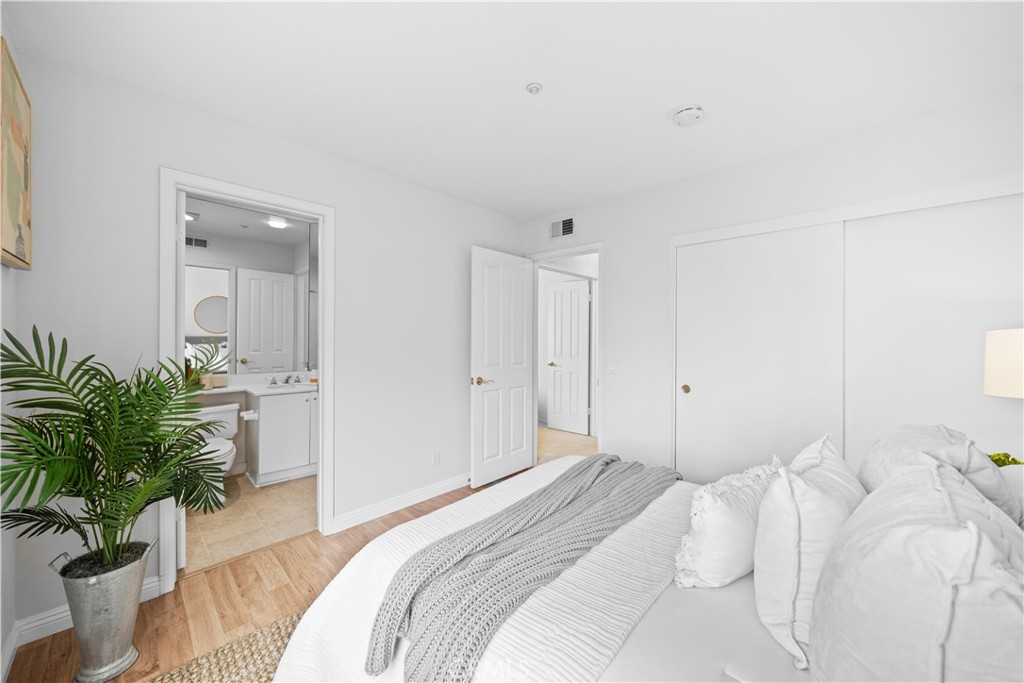 6 Arese Aisle Irvine, CA 92606 - Photo 28 of 38 a bedroom with a bed and a potted plant