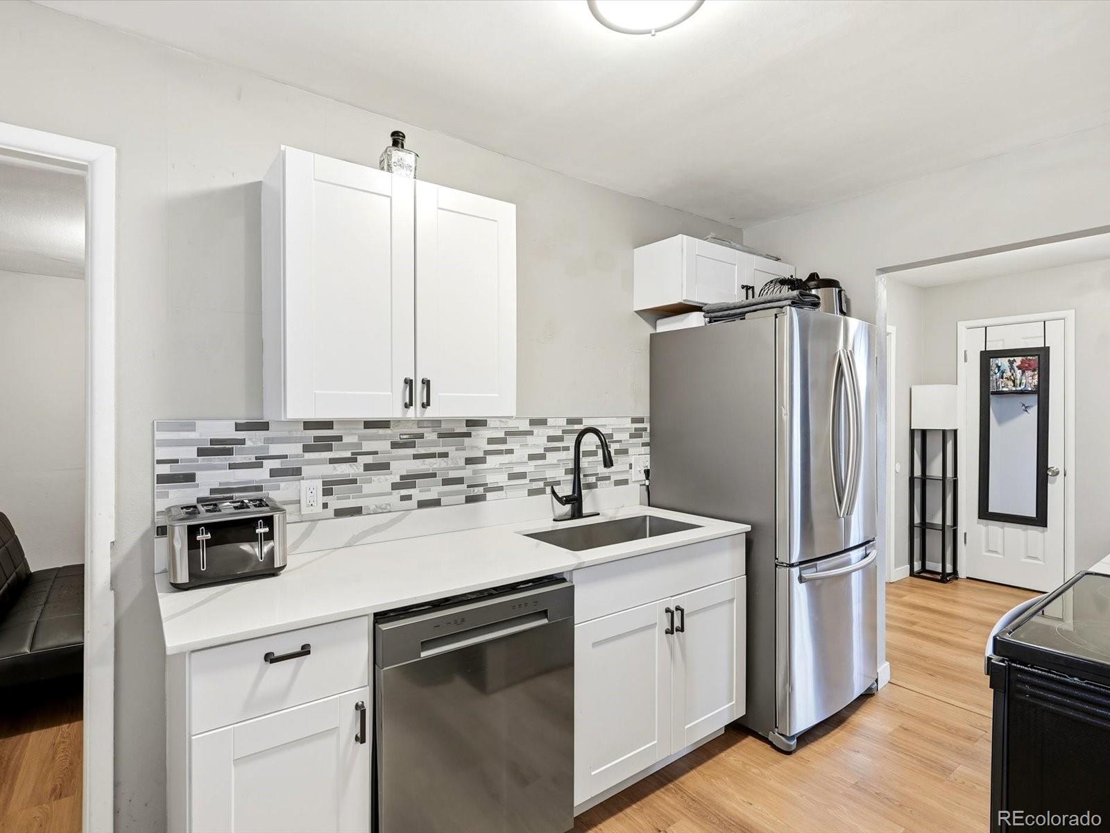 1883 South Perry Way Denver, CO 80219 - Photo 12 of 36 a kitchen with a sink stove and refrigerator