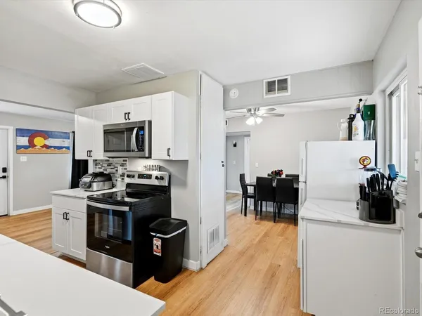 a kitchen that has a lot of cabinets a sink and appliances